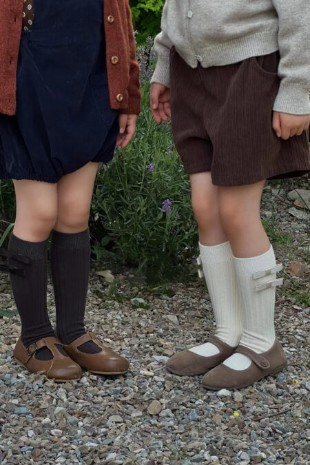 Brązowe podkolanówki z dwiema kokardkami dla dziewczynki, stylowe i wygodne.
