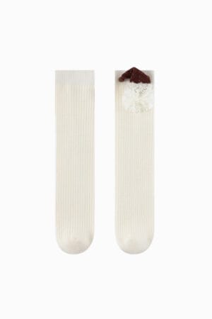 Calzettoni bianchi per bambine con decorazione di Babbo Natale e pompon. Design a righe.