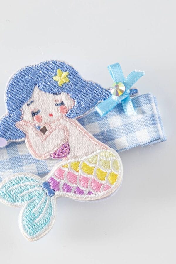 Horquilla de sirena para niñas, con colores azul, rosa, amarillo y detalles bordados.