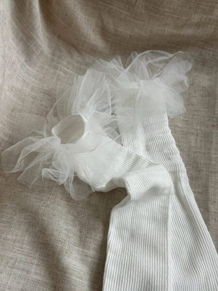 Calcetines blancos hasta la rodilla para niñas, con volantes de tul en la parte superior.