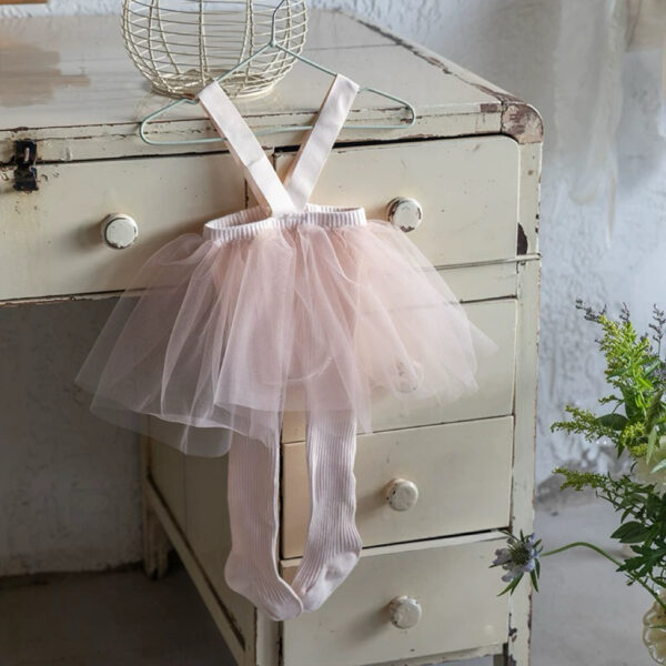 Pink tutu with tulle ruffles and suspenders for a girl, with white tights.