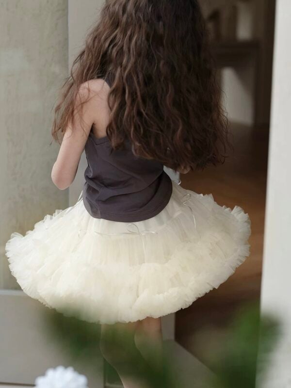 Cream-colored tutu skirt made of tulle, with decorative bows, for a girl.