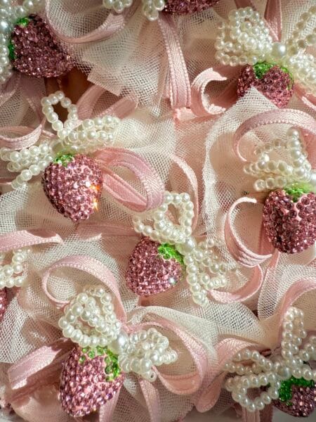A set of pins for a girl with pink strawberries and pearl bows.