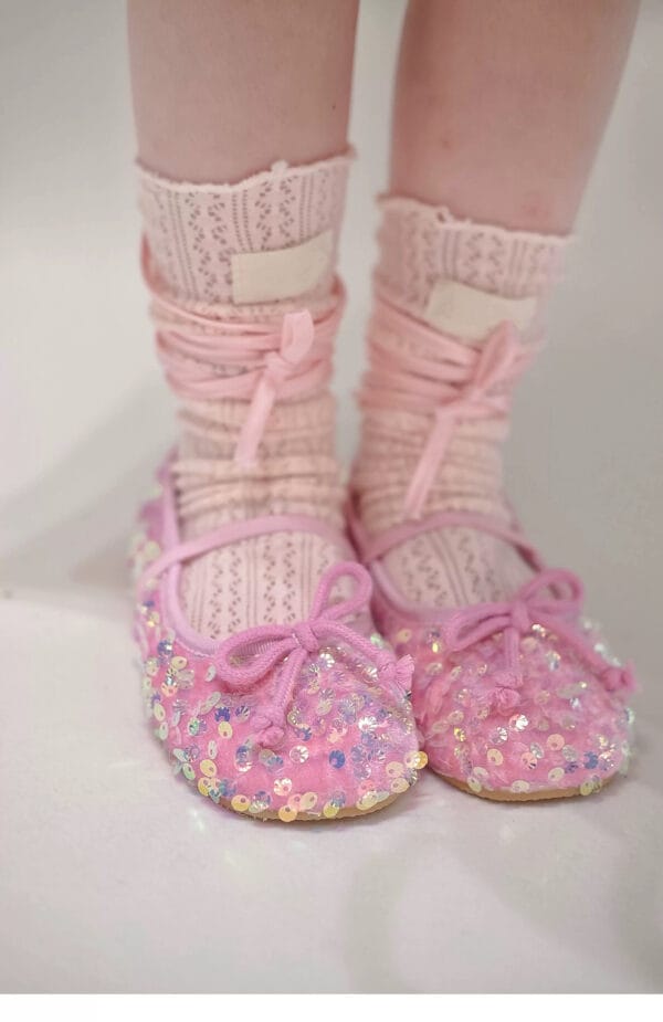Bright pink ballerinas for girls decorated with sequins and a bow, with a soft upper.