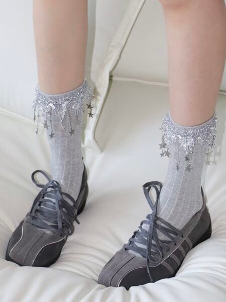 Chaussettes pour filles en gris avec des étoiles décoratives et des détails pailletés.