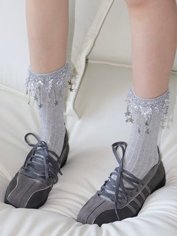 Chaussettes pour filles en gris avec des étoiles décoratives et des détails pailletés.