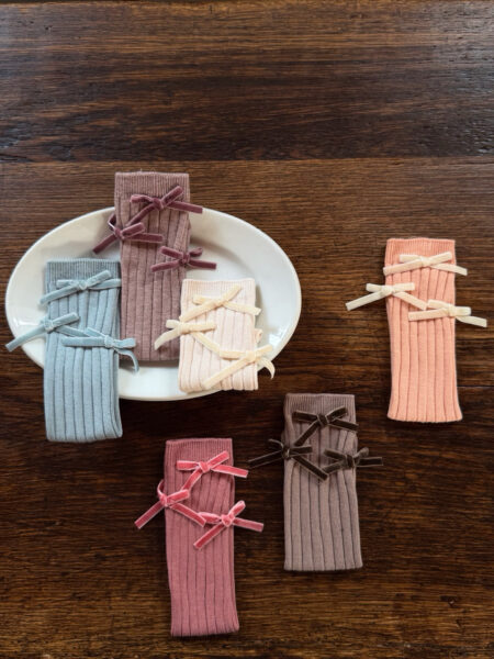 Chaussettes pour filles en rose, bleu, beige et marron avec des nœuds décoratifs.