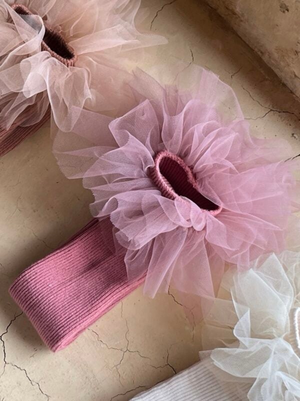 Knee-length girls' socks in pink with tulle trim.