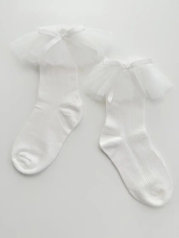 Chaussettes pour filles en blanc avec bordure en tulle et nœud en satin.