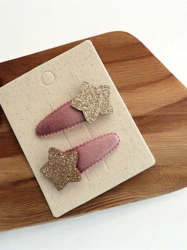 Velvet star hair clips in pink and gold shades for a girl, with glitter finish.