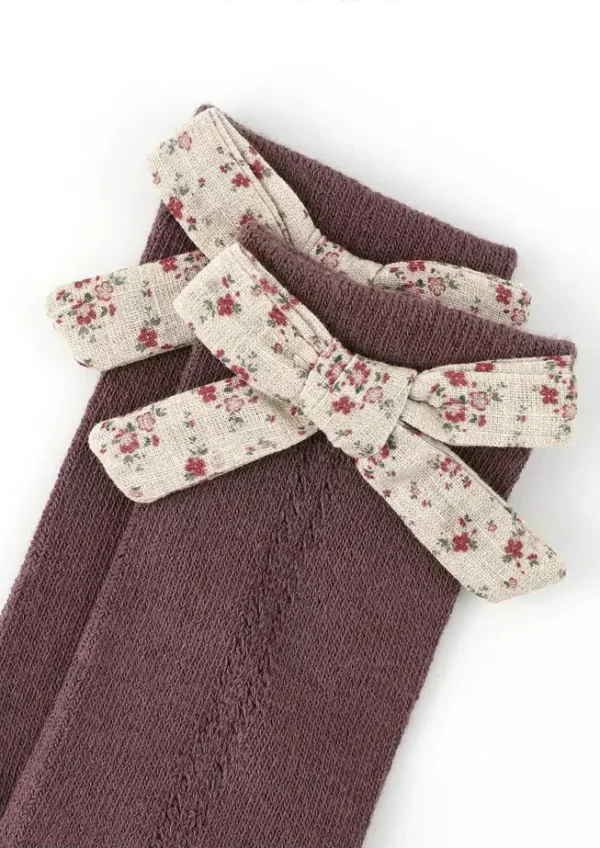 Calcetines de color ciruela con un lazo floral para niña.