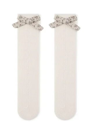 Light beige openwork socks adorned with a floral bow detail.
