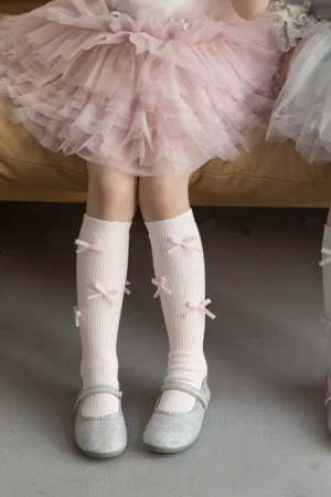 Rosa Tüllrock für Mädchen mit weißen Socken mit Schleifen und glänzenden Schuhen