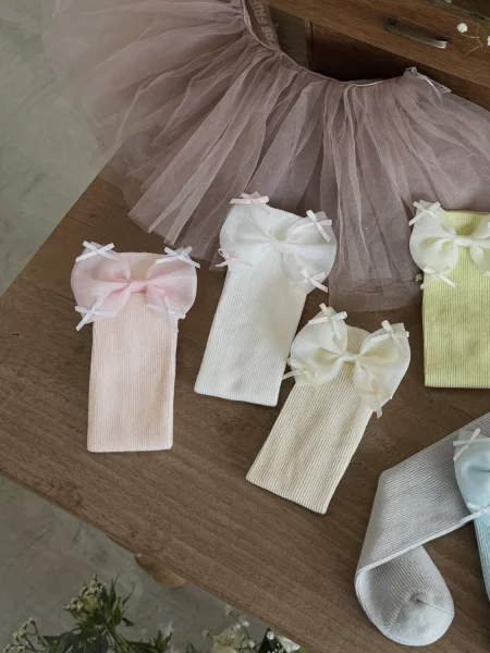 Skarpetki dla dziewczynki w pastelowych kolorach z kokardkami, w komplecie z tiulową spódnicą.