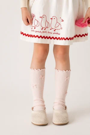 Hellrosa gerippte Mädchensocken mit Schleifen.