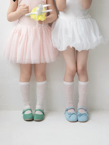 Falda rosa y blanca para niña, calcetines con perlas y zapatos coloridos.