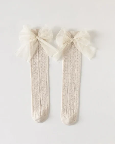 Calzini ecru da bambina con fiocchi in tulle in alto e delicato motivo.