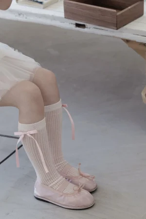 Różowe baleriny i skarpetki z kokardkami dla dziewczynki. Elegancki, delikatny styl.