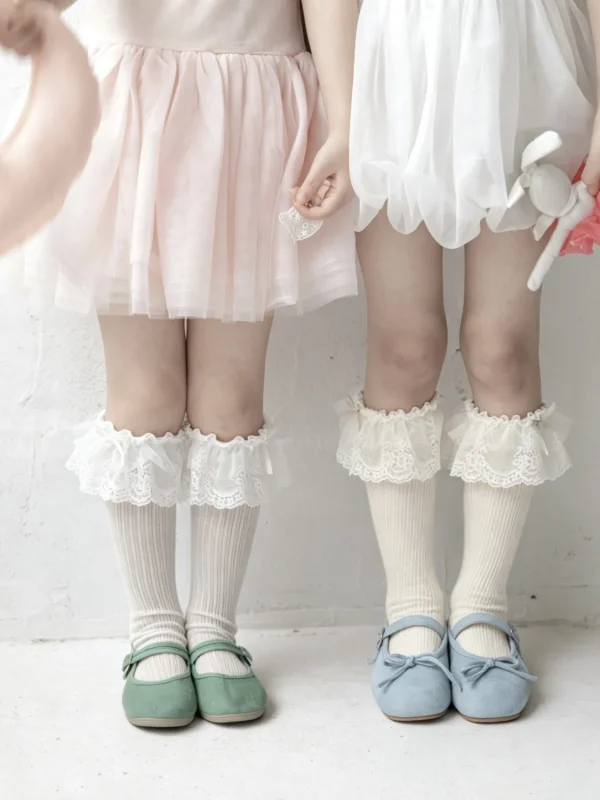 White frilly socks for girls, paired with pink and white skirts.