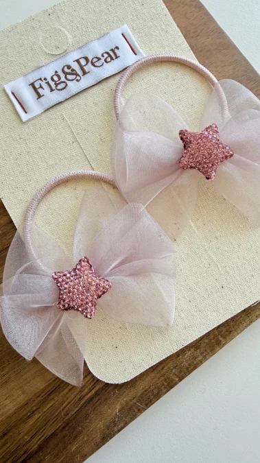 Gomas rosas para el pelo de niña con lazos de tul y estrellas brillantes.