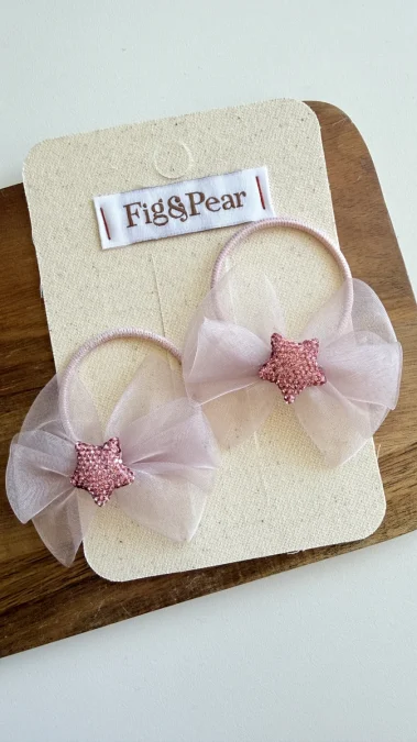 Pinzas para el pelo de niña en rosa claro con lazos de tul y estrellas brillantes.