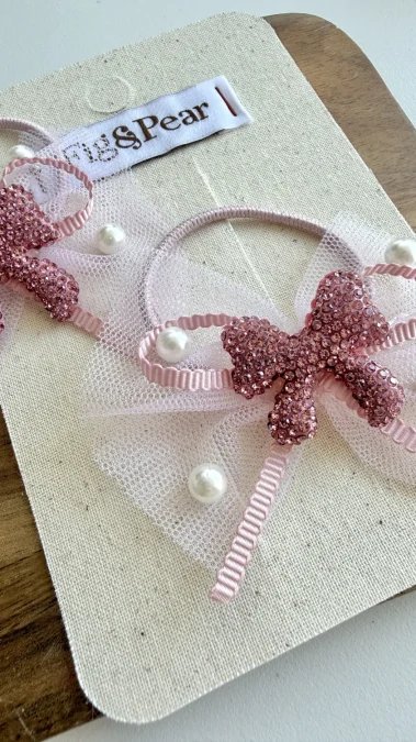 Pink hair accessory for a girl with crystals and pearls on a tulle ribbon.