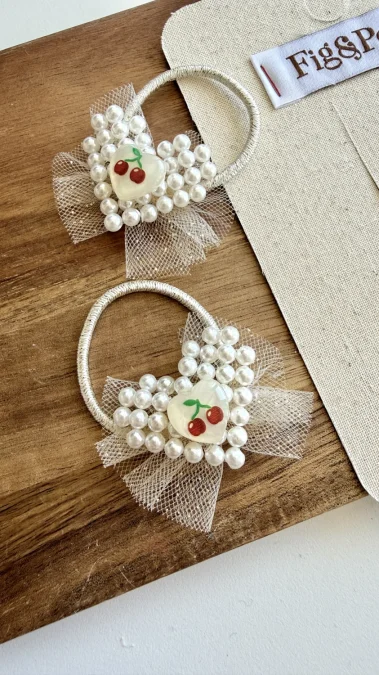Girl's hair bobbles with pearls, tulle and a heart-shaped cherry decoration.