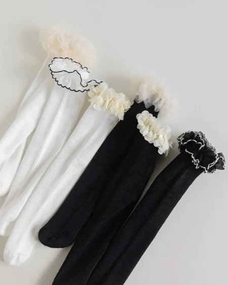 Mädchensocken im 3er-Pack, weiß und schwarz, mit Spitzenrüschen.