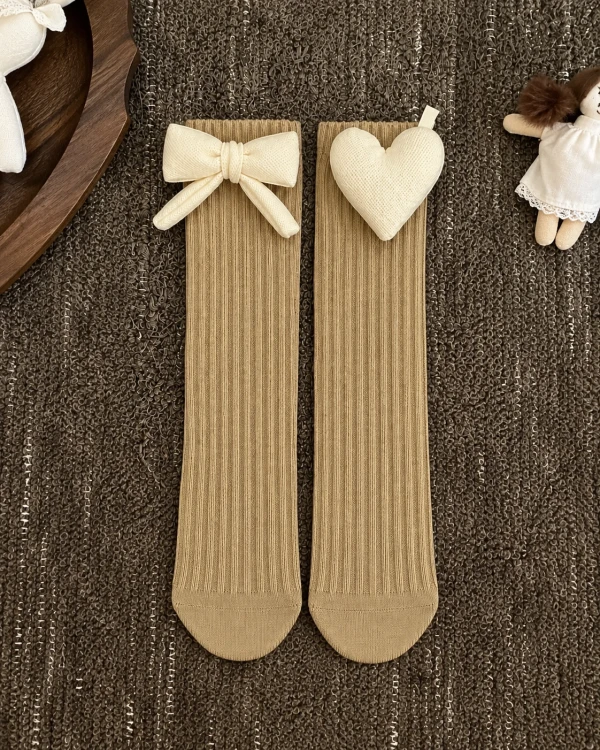 Beige girls' socks with a side bow, 3D heart and ribbed pattern.