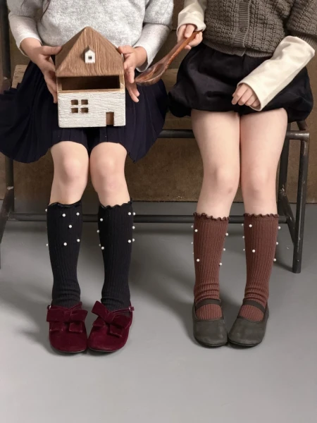 Chaussettes fille noires à perles et marron, assorties à des jupes à volants.